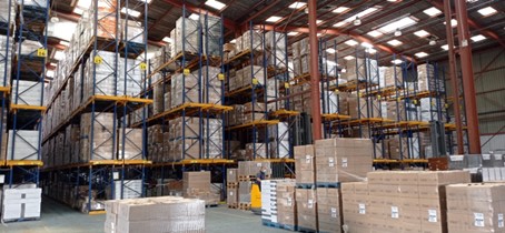 Racks contenant des cartons de capsules de café Kabioca stockées en attendant la préparation de commande