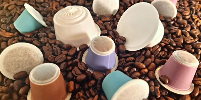 Capsules compostables végétales Kabioca compatibles Nespresso et Dolce Gusto au milieu de grains de café