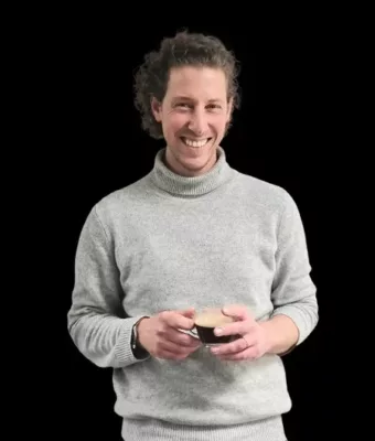 Thomas, fondateur de la marque de café Kabioca et passionné de café, pose avec une tasse de café à la main